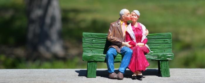 liefde - een porseleinen ouder echtpaar kust elkaar op een bankje